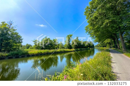 Enjoy a Serene Canal View on a Beautiful Sunny Day, Surrounded by Lush Greenery and Nature 132033275