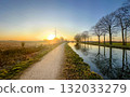 Experience the Scenic Sunrise by the Tranquil Canal Path, filled with beauty and serenity 132033279