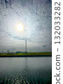 A Beautiful and Serene Landscape Featuring a Communication Tower and Reflective Water 132033282