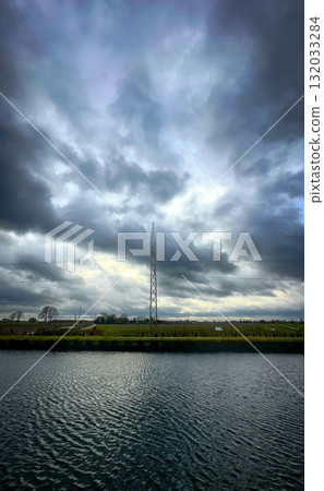 A Dramatic Sky Over Water with a Nearby Communication Tower Created an Impactful Scene 132033284