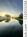 A Serene Sunrise Reflection Casts a Beautiful Image Over a Calm and Peaceful Canal 132033288