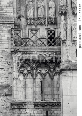 A wall of an old Catholic church with a balcony and various decorative stone elements. Vertical black and white photo A wall of an old Catholic church with a balcony and various decorative stone elements. Vertical black and white photo 132033336