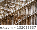 An old stone wall with carved Gothic decorative elements arranged diagonally, partially painted and whitewashed. Horizontal color photo 132033337
