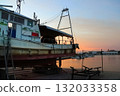 Fishing boats and fishing port illuminated by the setting sun 132033358