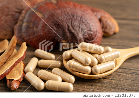 Dried lingzhi mushroom with capsule drug, alternative medicine herbal organic herb. 132033375