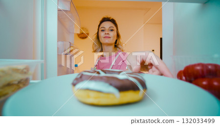 Pregnant woman enjoys smelling dessert out of fridge and caresses her belly. Pregnant woman enjoys smelling dessert out of fridge and caresses her belly. 132033499