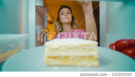 Hungry pregnant female looking around into the refrigerator not sure what to eat 132033503