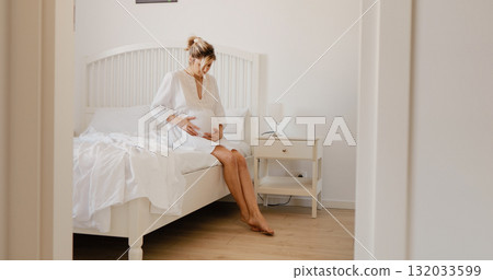 Pregnant woman suffering with pain in her belly on bed at home. Pregnant woman suffering with pain in her belly on bed at home. 132033599
