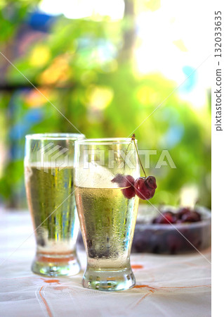 Two Glasses of Cold Sparkling Drink with Cherries on Sunny Summer Patio Two Glasses of Cold Sparkling Drink with Cherries on Sunny Summer Patio 132033635