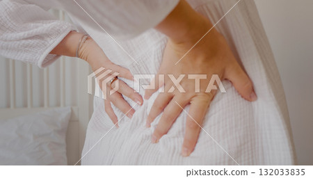 Young pregnant woman stretching back muscles and touching her belly. 132033835