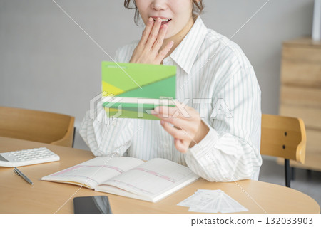 A woman looking at a passbook 132033903