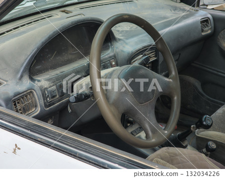 Dusty car interior with neglected dashboard and steering wheel 132034226