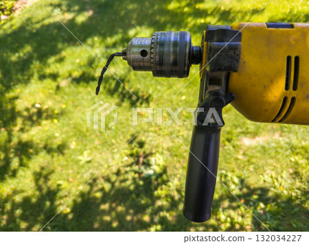 drill with bent chinesium drill bit in outdoor garden during daytime 132034227