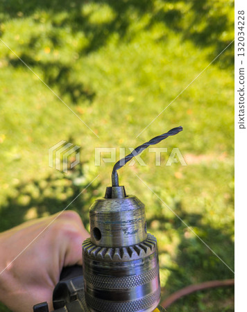 drill with bent chinesium drill bit in outdoor garden during daytime 132034228