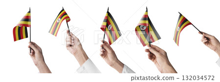 The Uganda flag in hand in different angles on a white background 132034572