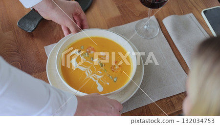 Waiter brings order for couples in restaurant. Couple sitting by table in a cafe. Customer service. 132034753