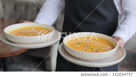 Waiter brings order for couples in restaurant. Couple sitting by table in a cafe. Customer service. 132034757