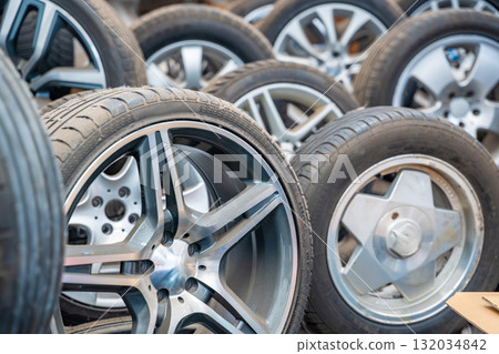 Different car wheels with tires arranged in a row inside an auto workshop. Seasonal tire replacement and service in preparation for winter in Czech Republic. Different car wheels with tires arranged in a row inside an auto workshop. Seasonal tire replacement and service in preparation for winter in Czech Republic. 132034842