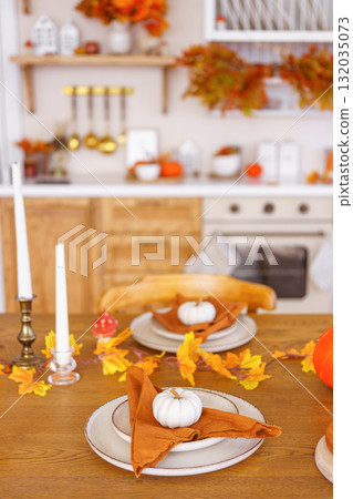 Autumn festive table setting with pumpkins and leaves for seasonal celebration, Halloween decor Autumn festive table setting with pumpkins and leaves for seasonal celebration, Halloween decor 132035073