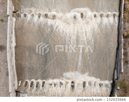 Aerial view of flowing water over concrete canal with dentate chute blocks 132035666