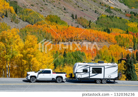Pickup truck with travel trailer on scenic country road with stunning view of colorful fall foliage 132036236