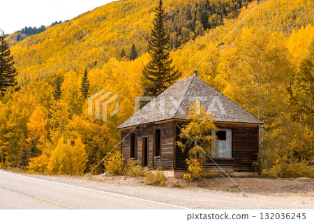 Wooden cottage near by the road with stunning yellow aspen trees on the mountain during fall foliage Wooden cottage near by the road with stunning yellow aspen trees on the mountain during fall foliage 132036245