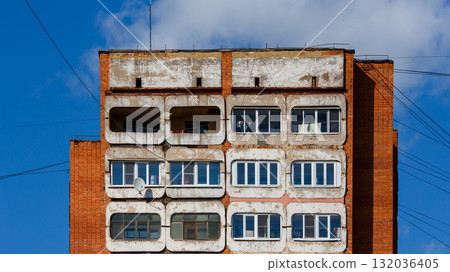 Weathered building with multiple rounded windows and balconies in urban setting Weathered building with multiple rounded windows and balconies in urban setting 132036405