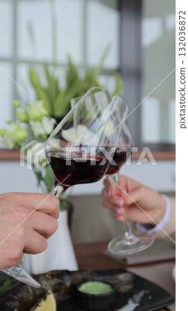 Vertical Video Couple clinking glasses of wine in restaurant. Two people celebrating anniversary together in cafe close-up. 132036872