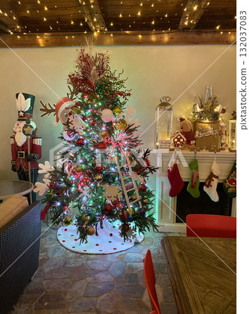 A cozy living room glows with a decorated Christmas tree and warm holiday lights. Stockings and ornaments add cheerful charm to the festive atmosphere. A cozy living room glows with a decorated Christmas tree and warm holiday lights. Stockings and ornaments add cheerful charm to the festive atmosphere. 132037083