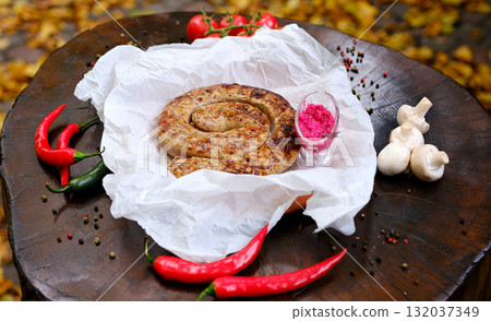 Grilled barbecue sausage with horseradish and red chili pepper Grilled sausages, cherry tomatoes, clean white. Food concept, simple composition, appetizing and ready for serving. Focus on textures. 132037349