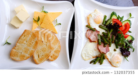 English muffin, scrumbled egg, ham, and cheese breakfast sandwich on a cutting board English muffin, scrumbled egg, ham, and cheese breakfast sandwich on a cutting board 132037355
