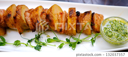Barbecue potato skewers with sausage salami and green onion close-up on the table. horizontal Barbecue potato skewers with sausage salami and green onion close-up on the table. horizontal 132037357