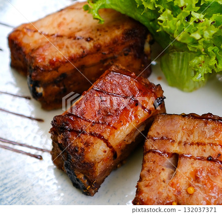 grilled pork ribs served with roast new potatoes on a white plate on a wooden table, horizontal view from above grilled pork ribs served with roast new potatoes on a white plate on a wooden table, horizontal view from above 132037371