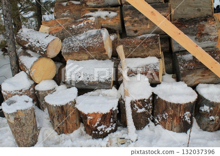 冬天的場景,柴火和斧頭被雪覆蓋 冬天的場景,柴火和斧頭被雪覆蓋 132037396