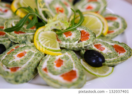 Spinach roulade stuffed with cream cheese and smoked salmon sliced on a white background, top view Spinach roulade stuffed with cream cheese and smoked salmon sliced on a white background, top view 132037401