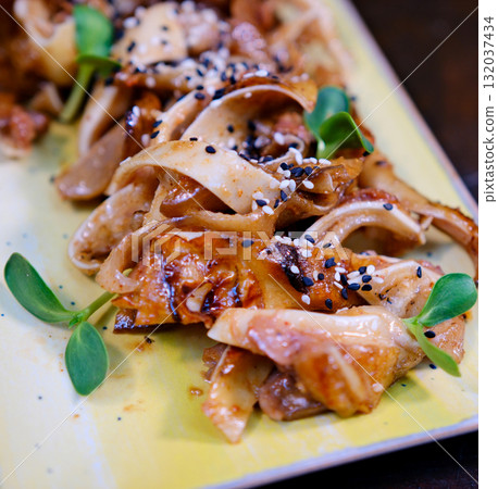 Pig Ears with spices and paprika on white plate, isolated on white background. Pig Ears with spices and paprika on white plate, isolated on white background. 132037434