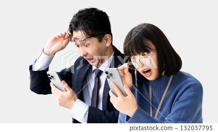 Two businessmen, male and female, surprised at their smartphones Two businessmen, male and female, surprised at their smartphones 132037795