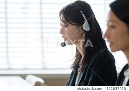 A woman working as a call center receptionist in an office A woman working as a call center receptionist in an office 132037930