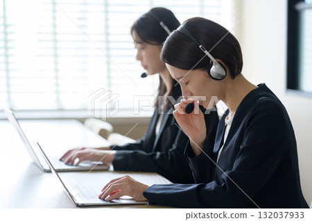 A woman working as a call center receptionist in an office A woman working as a call center receptionist in an office 132037933