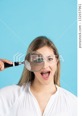 Studio portrait of woman with magnifying glass 132037961