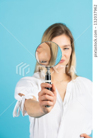 Studio portrait of woman with magnifying glass 132037962