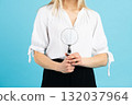 Studio portrait of woman with magnifying glass 132037964