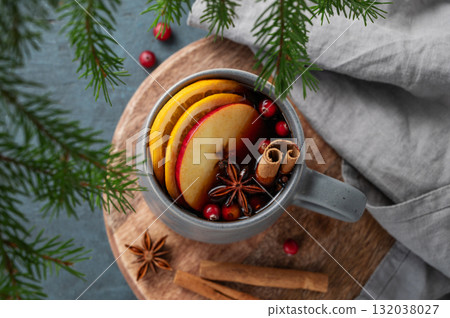 A cup of red mulled wine with spices, orange, apple slices and cranberry on a dark background A cup of red mulled wine with spices, orange, apple slices and cranberry on a dark background 132038027