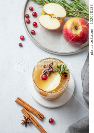 Hot apple cider with cinnamon, anise, brown sugar and rosemary in a glass on a light background 132038128