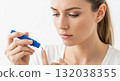 Woman performing a blood glucose test on her finger with a lancet device. Patient self-monitoring for diabetes management. Healthcare and medical concept 132038355