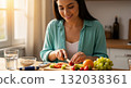 Hispanic woman managing diabetes by preparing a healthy meal. Slicing fresh fruit with a blood glucose meter on the counter. Healthy lifestyle and nutrition concept 132038361