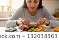 Hispanic woman preparing a healthy diabetic breakfast with fresh fruit. Blood glucose meter on the table for sugar level monitoring. Diabetes management and healthy lifestyle concept 132038363