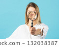 Studio portrait of woman with magnifying glass 132038387