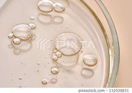Petri dish with shower gel or shampoo with bubbles on beige background. Petri dish with shower gel or shampoo with bubbles on beige background. 132038631