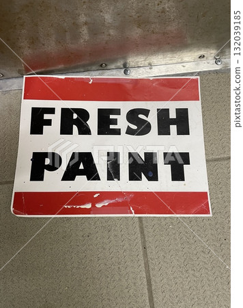 Freshly painted sign with black lettering on red and white card 132039185